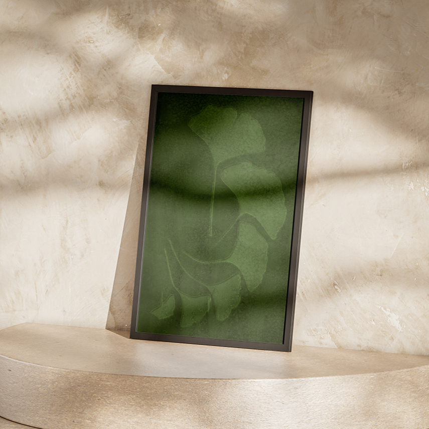 Framed abstract artwork on a pedestal against a textured wall.