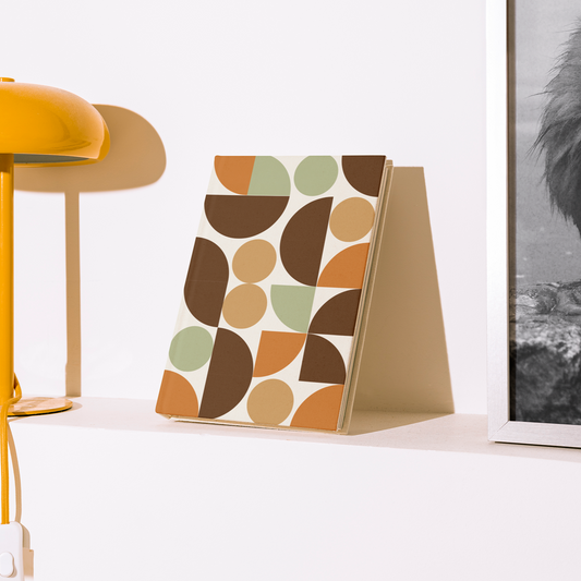 Yellow lamp and decorative book on a white surface with a framed black and white photo in the background.